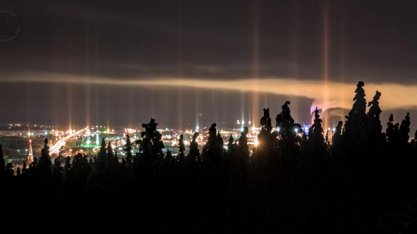 light rising stright into sky from city lighting