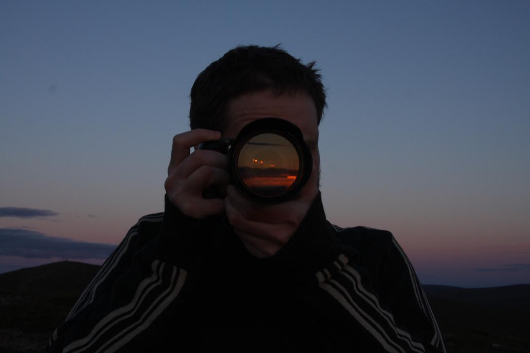 Person holding a camera in front of face